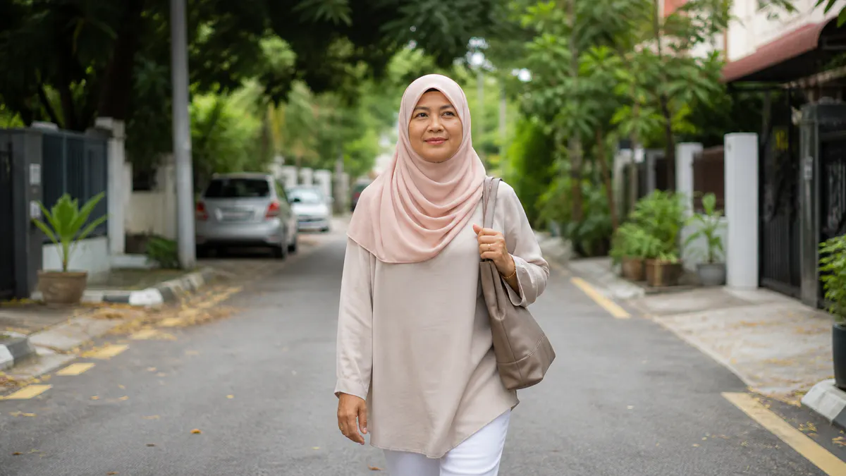 Wanita Melayu berjalan di kawasan bandar Malaysia yang redup.