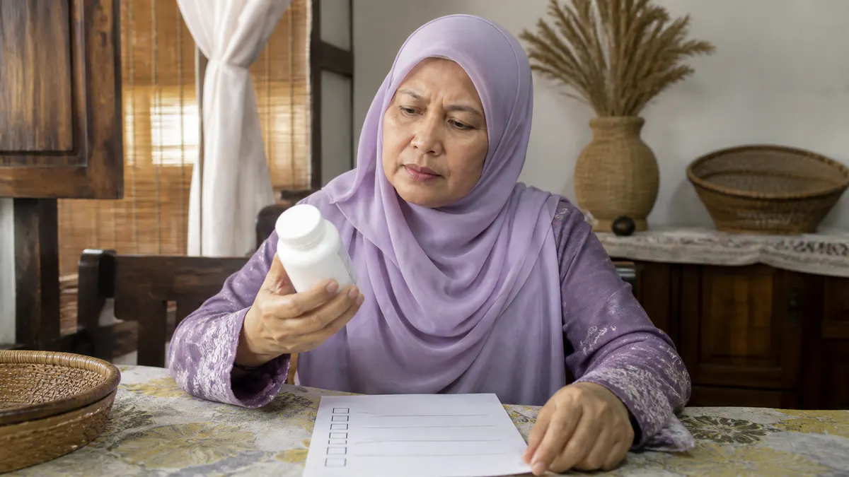 Wanita Melayu memeriksa produk tanpa jenama dengan berhati-hati.